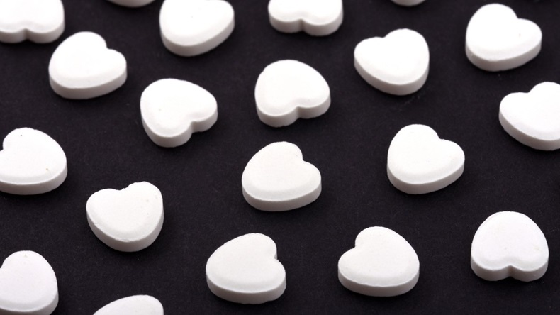 Heart shaped pills on a black background