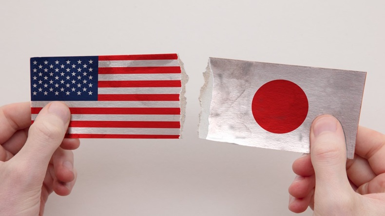 USA and Japan flags ripped apart