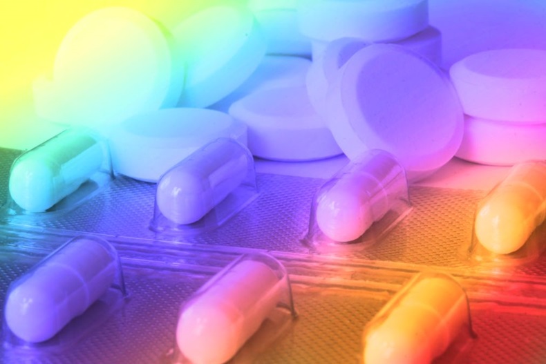 Pile of pills in color fantasy with psychedelic colors showing confusion or disorientation due to drugs with copy space