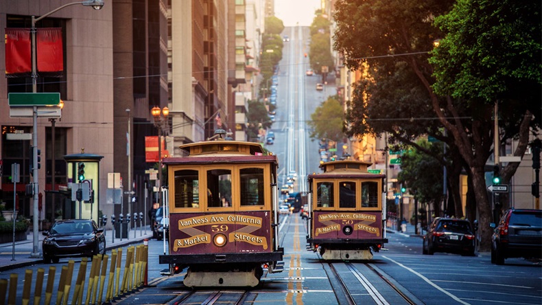 Classic view of historic traditional Cable Cars riding on famous California Street in morning light at sunrise with retro vintage style cross processing filter effect, San Francisco, California, USA - Image 