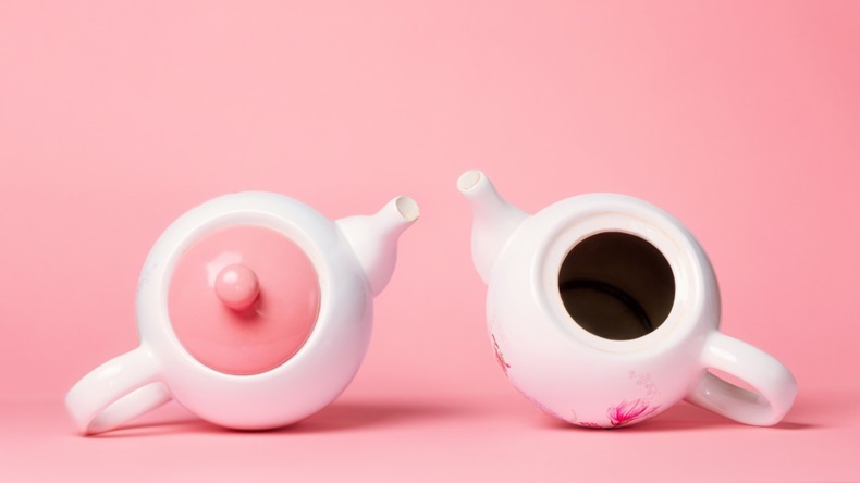 Two teapots, one with pink lid, one with no lid and dark hole, representing breasts and breast cancer
