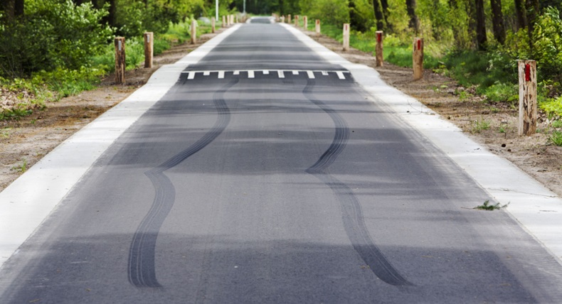 Skid marks in front of speed bump on a asphalt country road