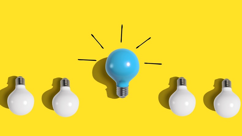 blue light bulb in middle of row of white light bulbs against yellow background