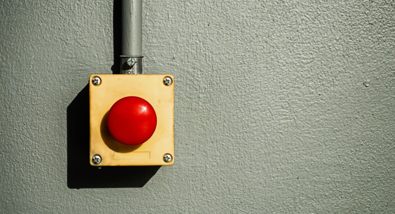 Big red button on a gray wall