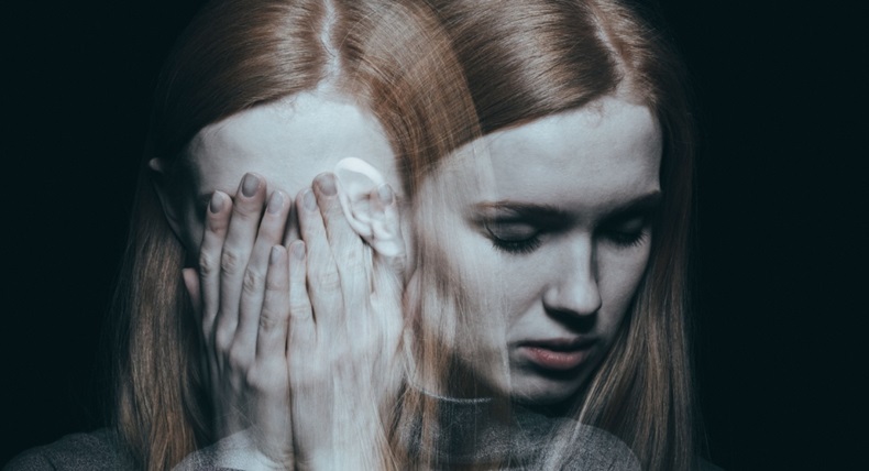Young girl covering her face with her hands after reaching a peak of her depression