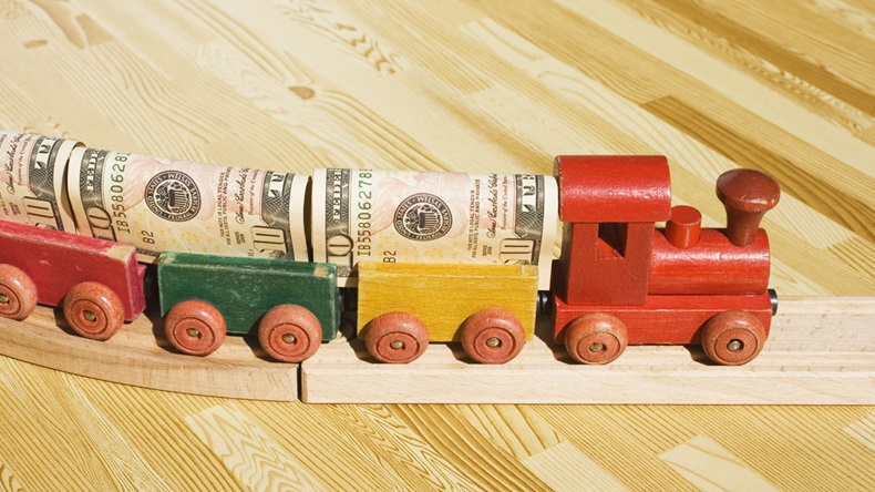 A toy train pulling a cargo of money This picture could be a reference to 'money delivery', gravy train, cargo, freight. Also, money supply and transferring money or wiring money.