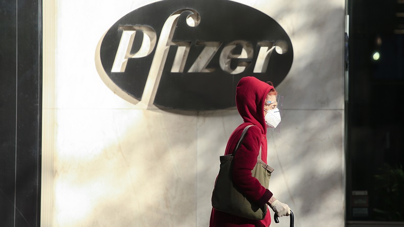 A woman wears a facemask as she walks by the Pfizer world headquarters in New York on November 9, 2020.